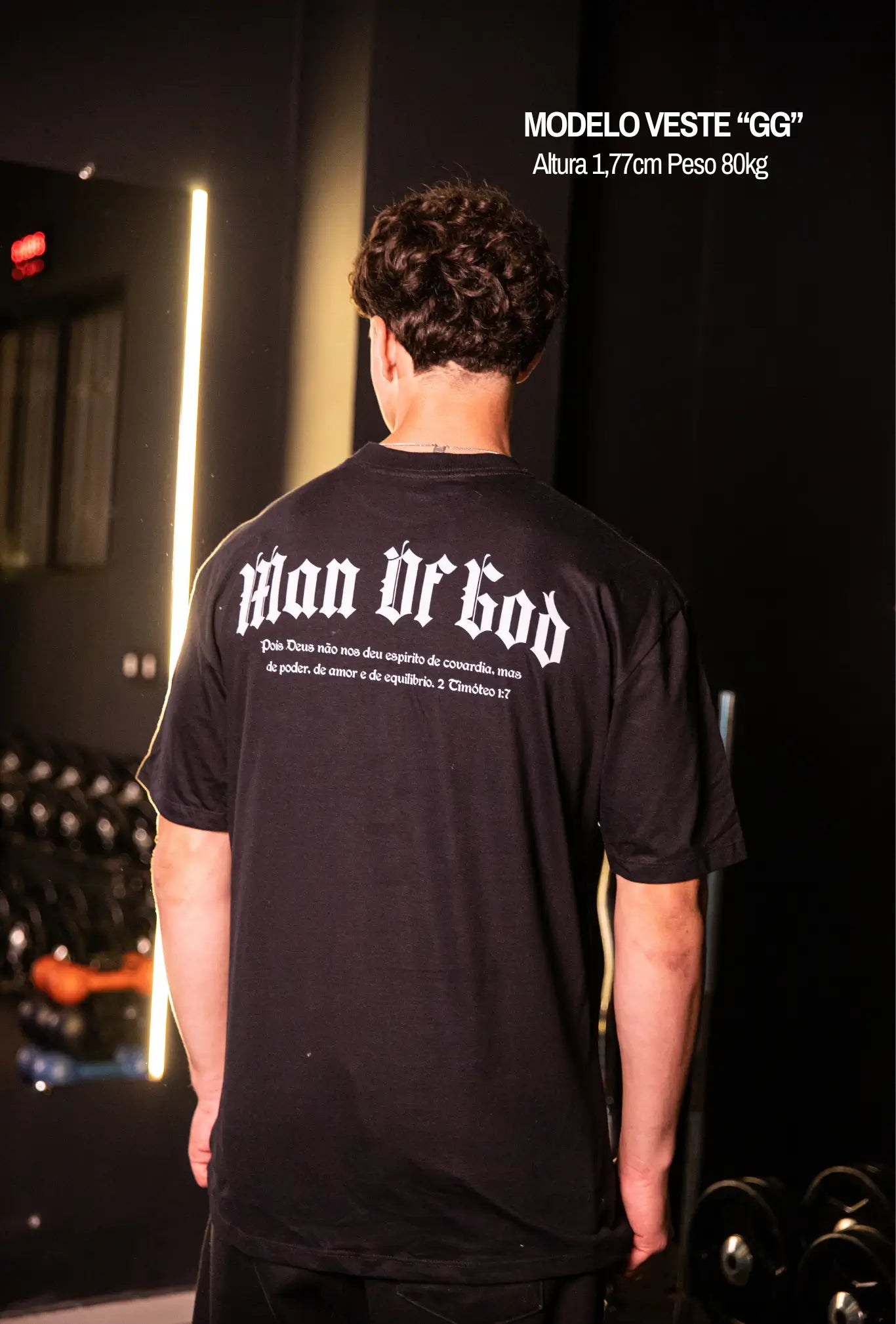 Camiseta oversized Man Of God GLORYFIT preta vista traseira em ambiente de academia