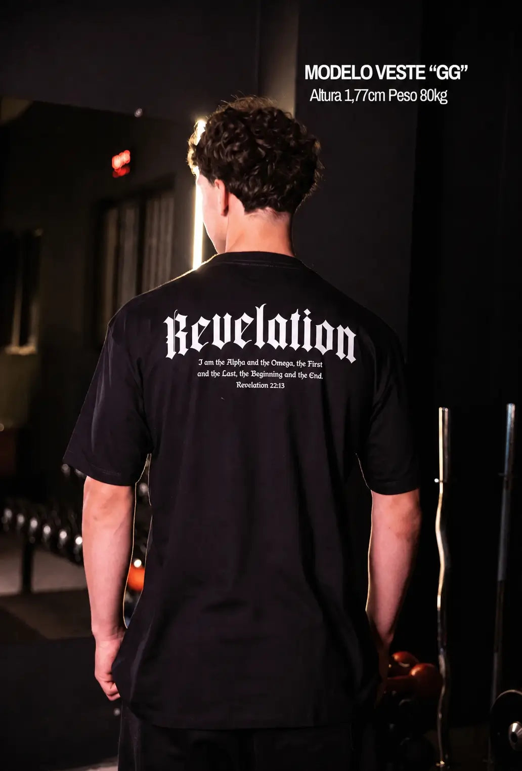 Modelo usando camiseta oversized preta Revelation com versículo Apocalipse 22:13 nas costas