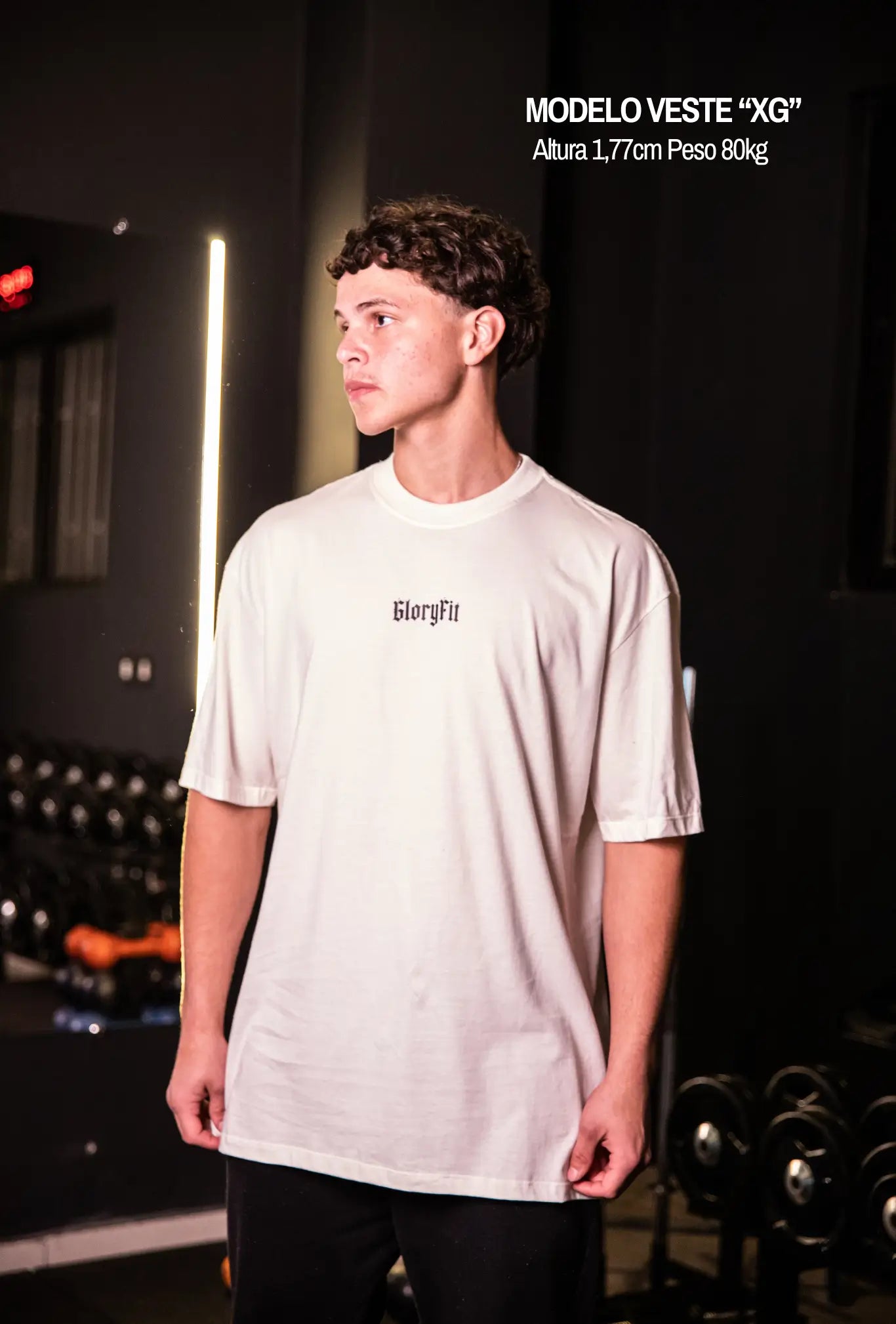 Camiseta oversized Risen GLORYFIT off white vista frontal com modelo em ambiente de academia