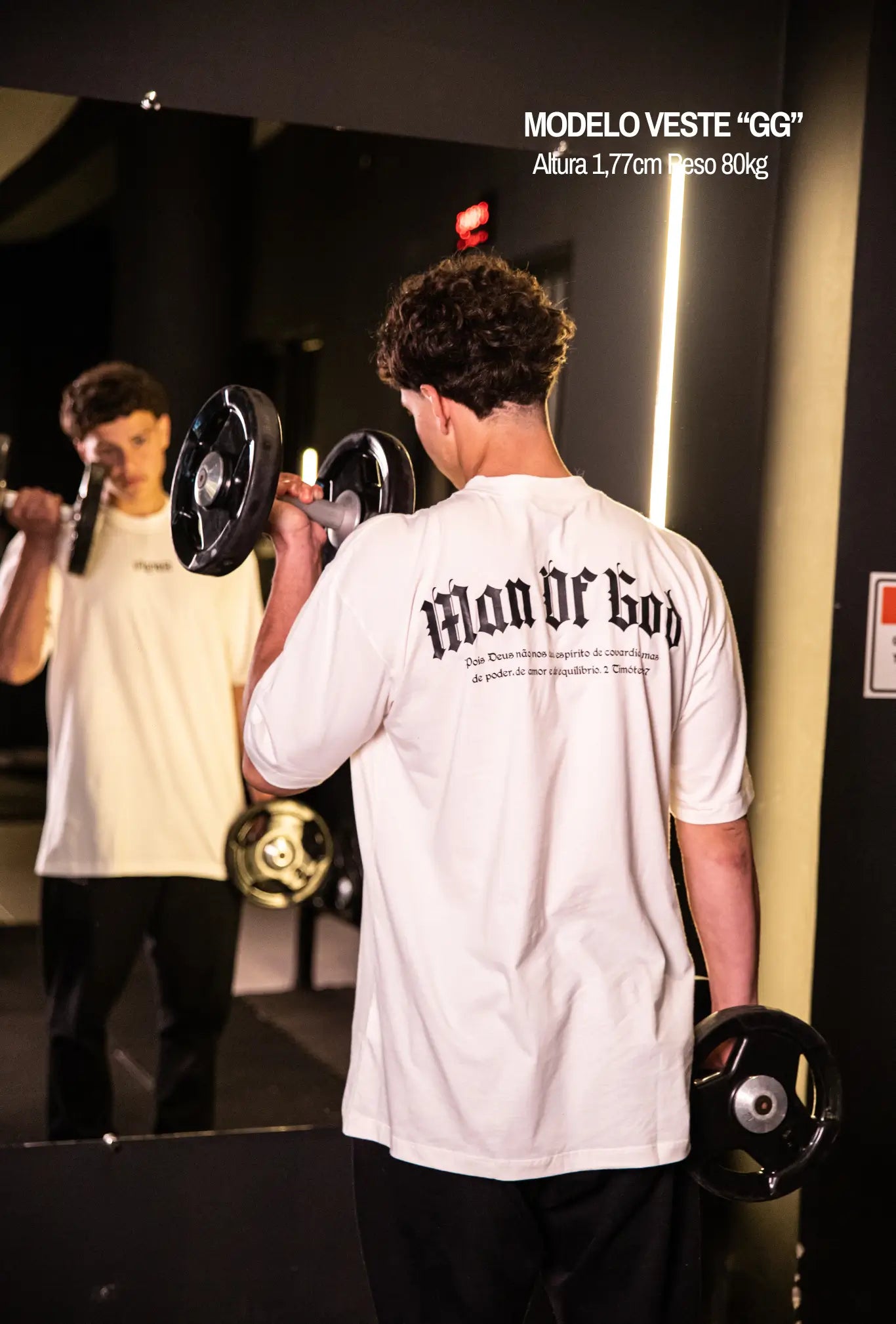 Camiseta oversized Man Of God GLORYFIT off white vista frontal com modelo em academia