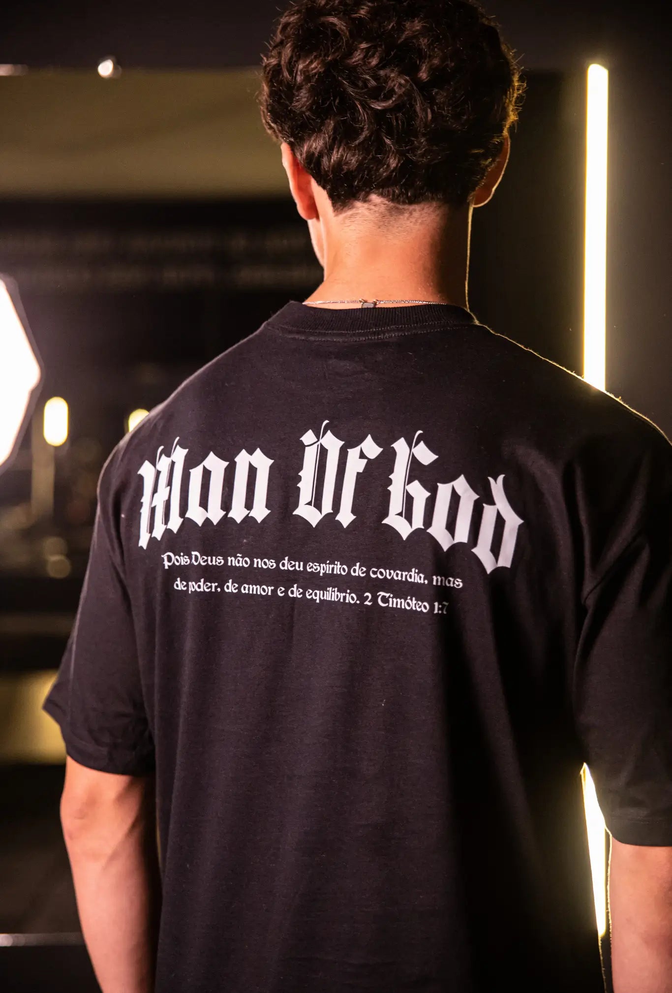 Camiseta oversized Man Of God GLORYFIT preta vista traseira com modelo em academia