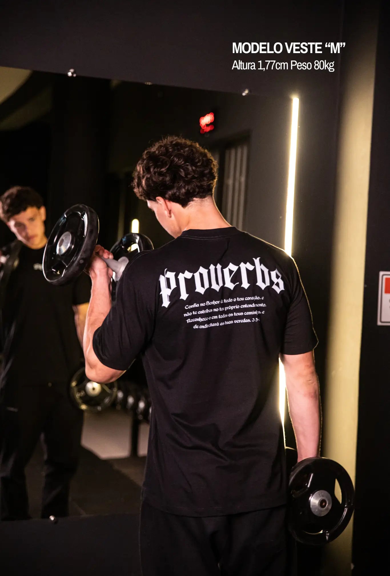 Camiseta oversized Proverbs GLORYFIT preta vista traseira com espelho em academia