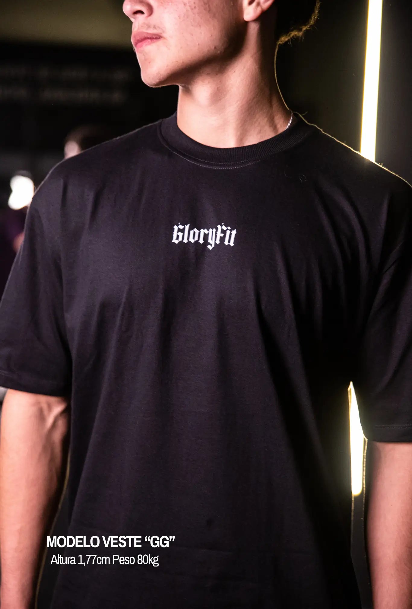 Camiseta oversized Risen GLORYFIT preta vista frontal com modelo em academia
